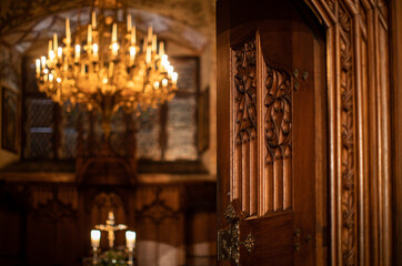 Splendid chandelier with lit candles in a beautiful room of an old mansion