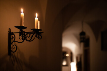 Splendid chandelier with lit candles in a beautiful room of an old mansion