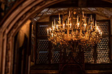 Splendid chandelier with lit candles in a beautiful room of an old mansion - obrazy, fototapety, plakaty