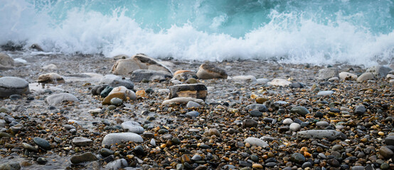 Variation de galets dans vagues et écume
