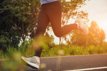 Athlete runner feet running on road, Jogging concept at outdoors. Woman running for exercise.