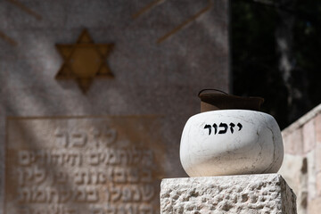 A stone marker holding an old soldier's helmet is engraved with the Hebrew word for 