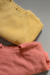 Various colors baby sweaters on dark gray background