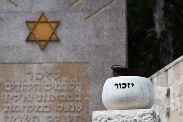 A stone marker holding an old soldier's helmet is engraved with the Hebrew word for 