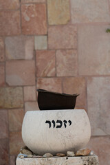 A stone marker holding an old soldier's helmet is engraved with the Hebrew word for 