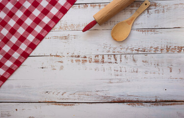 Utensilios de cocina en una mesa de madera y mantel