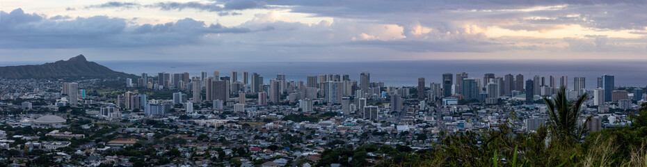 Fototapeta na wymiar Honolulu skyline under cloudy skies at sunset