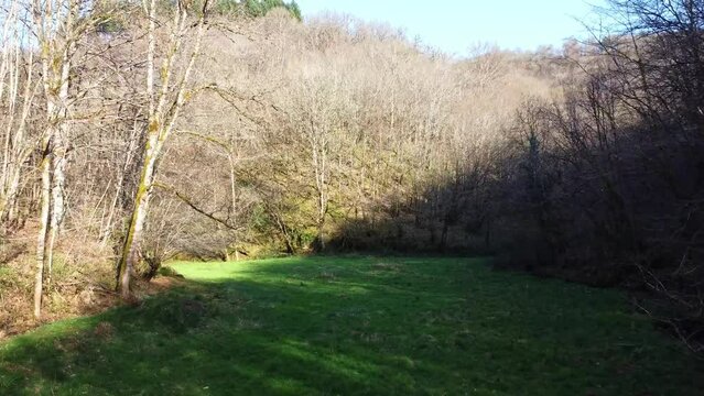 Vall&eacute;e cach&eacute;e entre ombre et lumi&egrave;re. Champ entre collines au printemps.