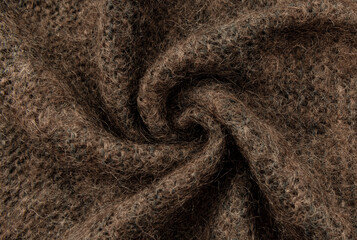Twisted brown lambswool fabric with waves and curves. Wool material. felt texture