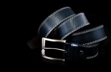 Men's leather belt in blue on a black background. Men's clothing accessory