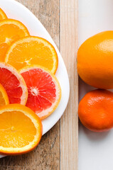 Sliced oranges and grapefruit on a wooden background. Top view.