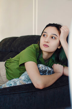 Portrait of a young beautiful girl lying on a sofa. Vertical photography.