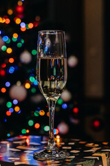 A glass of champagne on the background of festive Christmas lights. Wineglass. bokeh. Christmas. New Year