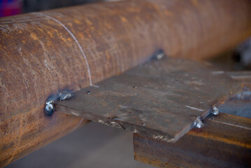 Welded butt joint. Rusty brown metal pipe steel plate welded together