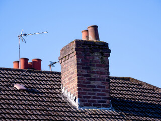 chimney and chimney pots on a tiled roofed house - obrazy, fototapety, plakaty