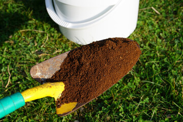Schaufel mit Kaffeesatz um den Kaffee im Rasen zu verteilen, als Dünger oder Mittel gegen Moos