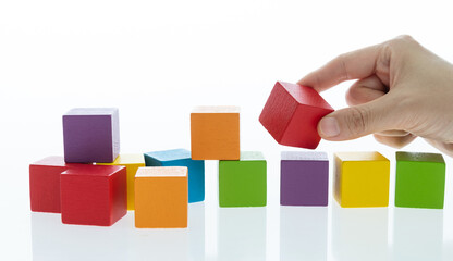 Human hand picking up a wooden block