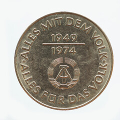 Germany East GDR - circa 1974: a 10 Mark coin of the GDR with the Hammer and Zirkle coat of arms of the GDR. Text: Everything with the people. Everything for the people