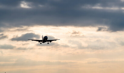 Fototapeta na wymiar Airplane flying in overcast sky