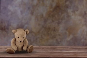 Brown little bear on a old wooden desk.