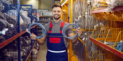 Portrait of friendly smiling salesman at modern DIY store or shopping mall. Happy handsome man in...