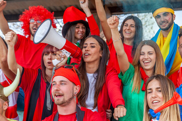 group of soccer fans watching a sports event in the stands of a stadium