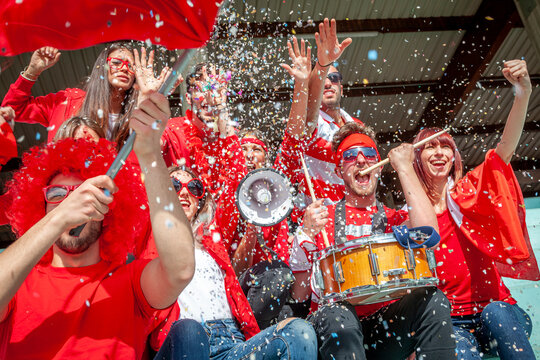 group of soccer fans watching a sports event in the stands of a stadium