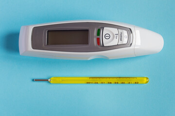 Two thermometers from different eras, one mercury and one with led display and laser technology...