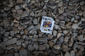 Top view of a king of clubs card on a pile of rocks