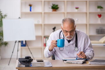 Old male doctor working in the clinic