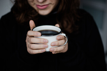 Mujer sosteniendo una taza de café antes de tomarlo. Concepto de bebidas.