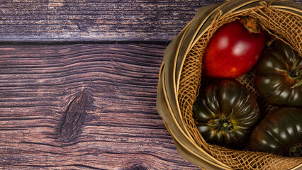 Fototapeta na wymiar ein Korb mit Tomaten auf einem alten Holztisch