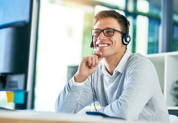 Going the extra mile to ensure customers stay happy. Shot of a young call center agent working in an office.