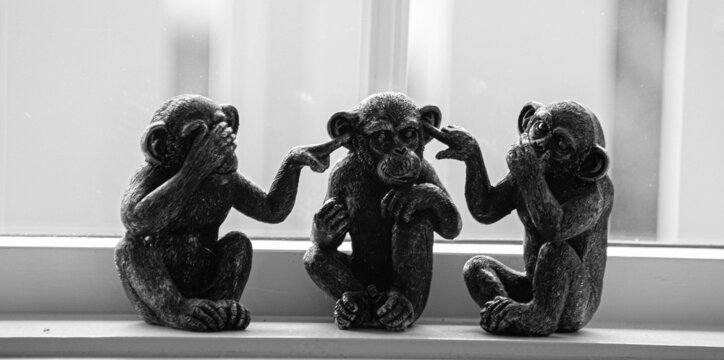 Grayscale shot of monkey figurines covering mouth, ears and eyes