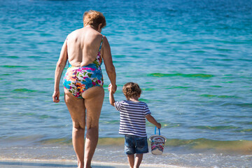 grandmother with grandson enjoying on the beach