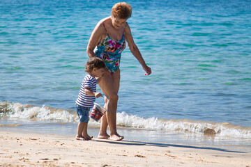 grandmother with grandson enjoying on the beach