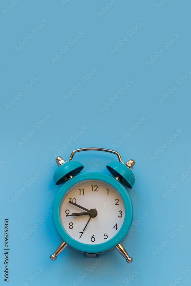 Poster alarm clock isolated on blue background with copy space