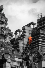 a Monk climbing the temples of Angkor Wat