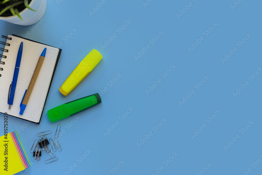 Poster flat lay of workspace desk on blue background with copy space