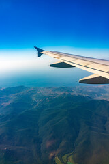 Fototapeta premium View from the airplane window at a beautiful blue clear sky and the airplane wing