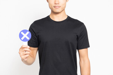 白い背景の前に立ってNGのプラカードを見せる黒いTシャツを着ている男性