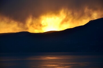 Sunset After The Mountains, Like Fire Flames. Intense orange sunset like burning sky in winter