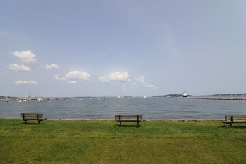 Natural view of empty benches on the seaside under a clear sly during summer