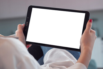 Frau hält iPad mit leerem Hintergrund in den Händen in der Wohnstube.