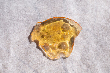 cannabis resin wax, yellow piece of marijuana extract.