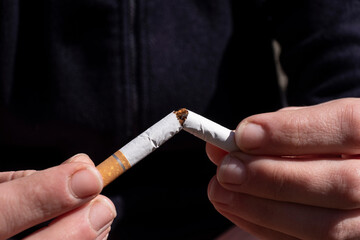 broken cigarette in hand, nicotine addiction stop smoking