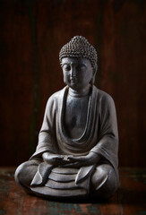 Meditating Buddha Statue on dark wooden background. Close up. 