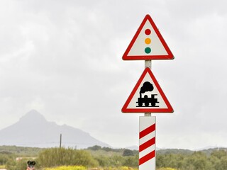 Paisaje con señales de peligro, de paso a nivel sin barrera y semáforo