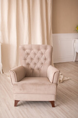 beige armchair in the interior of the children's room in pink tones
