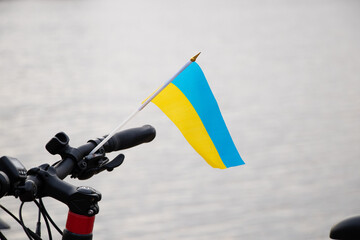 Yellow-blue flag of Ukraine on a bicycle in a city in Ukraine, a protest action, stop the war in...